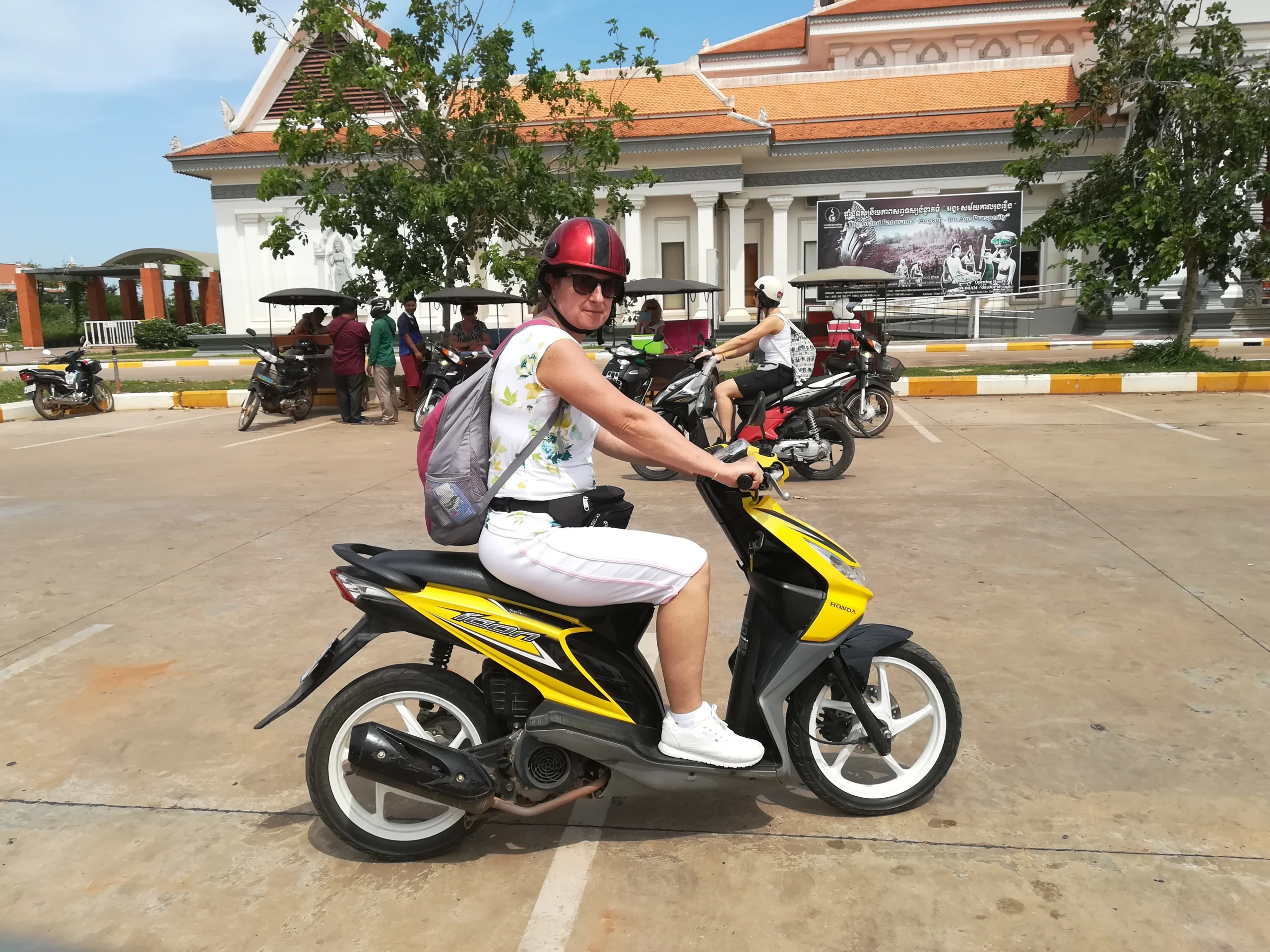 Egyedül motorozó nő egy kambodzsai úton alkonyatkor, eltévedés után